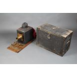 A Victorian japanned metal magic lantern on an oak base with brass mounts 51cm h x 61cm w x 30cm