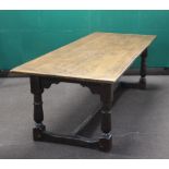 A 17th Century style elm refectory dining table raised on cup and cover supports 74cm h x 244cm l