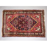 A Persian blue and red ground rug with central medallion 119cm x 78cm Light water marks and signs of