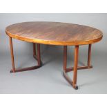 A Danish mid 20th Century rosewood oval extending dining table with 2 extra leaves, raised on square