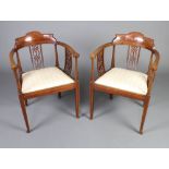 A pair of Edwardian inlaid mahogany tub back chairs with upholstered drop in seats, raised on square