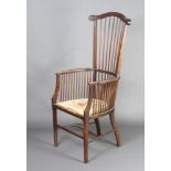 An Arts and Crafts mahogany stick and rail back armchair with Berlin woolwork seat raised on
