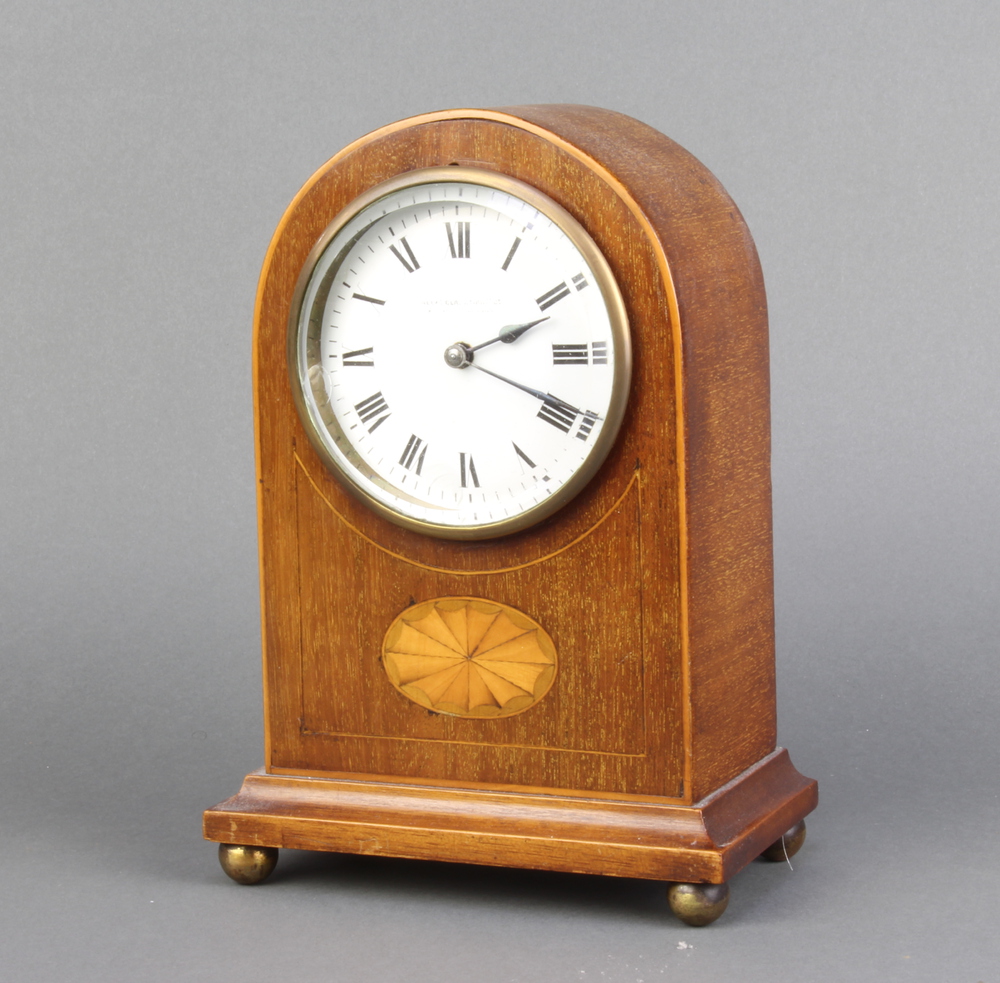 An Edwardian timepiece with enamelled dial and Roman numerals, contained in an arched inlaid
