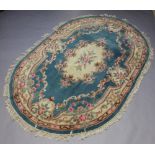 An oval blue and floral patterned Indian carpet 267cm x 178cm Some staining