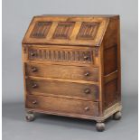 An Ipswich style carved oak bureau, the fall front with carved linenfold decoration above 4 drawers,