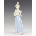 A Lladro figure of a lady holding a bouquet of flowers 5604 22cm