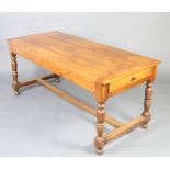 A 19th Century oak dining table fitted a drawer, raised on turned supports with H framed stretcher