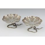 A pair of Indian repousse silver table salts decorated with animals, raised on cobra bases 6cm,