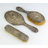 An Edwardian repousse silver oval hand mirror Birmingham 1902 and a similar hair and clothes brush