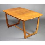 A mid Century teak Astro style extending dining table with concealed extra leaf, raised on shaped