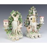 A pair of 19th Century Continental candlesticks with classical figures standing before bocage,