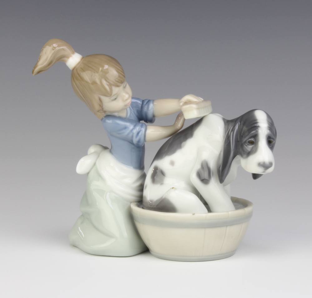 A Lladro group of a girl washing a hound in a barrel 5455 13cm