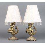 A pair of gilt metal table lamps in the form of cherubs sat upon a cornucopia 19cm h x 7cm diam.