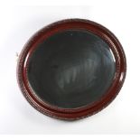 An oval plate wall mirror contained in a decorative mahogany frame 62cm x 75cm