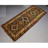 A blue and tan ground Caucasian style rug with 6 diamonds to the centre within a multi row border