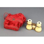 A pair of 19th Century gilt metal and ivory opera glasses contained in a plush red material bag