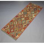 An orange, green and turquoise ground Chobi Kilim runner with all over geometric designs 240cm x