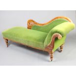 A Victorian carved mahogany show frame chaise longue upholstered in green material raised on