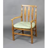 A beech framed open arm stick and wheel back chair with woven cane seat