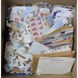 A quantity of stamped envelopes and world stamps contained in a large cardboard box