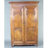 A French 17th/18th Century carved oak armoire with moulded cornice and shelved interior enclosed