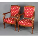A pair of French Empire show frame mahogany open arm chairs, the seats and backs upholstered in