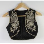 A small black and silver Bolero waistcoat together with 2 Victorian white fabric mess waistcoats and