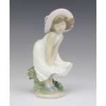 A Lladro figure of a young girl wearing a bonnet 17cm
