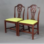 A pair of Hepplewhite style mahogany dining chairs with upholstered drop in seats raised on square
