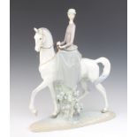 A Lladro figure of a lady on horseback 45cm The leather reign has perished on one side and there