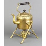 An Art Nouveau circular embossed brass spirit kettle raised on a crabstock supports, complete with