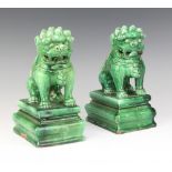 A pair of Chinese green glazed figures of Shi Shi on rectangular bases 20cm Both are chipped