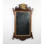 A Chippendale style rectangular plate wall mirror contained in a walnut frame surmounted by an eagle