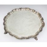 An Art Deco silver salver with pie crust rim, raised on hoof feet, Sheffield 1934, 1155 grams