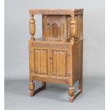 A 1930's oak court cupboard, the top fitted a secret drawer with cupboard enclosed by arch