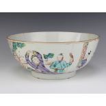 An 18th Century Chinese famille rose bowl decorated with figures, dog and a boy holding a bird of