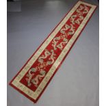 A red and cream ground Chinese runner decorated dragons 371cm x 76cm Some staining in places