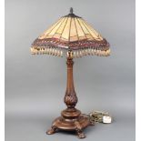 A Tiffany style bronzed table lamp with stained glass shade, raised on 4 hoof supports 73cm h x