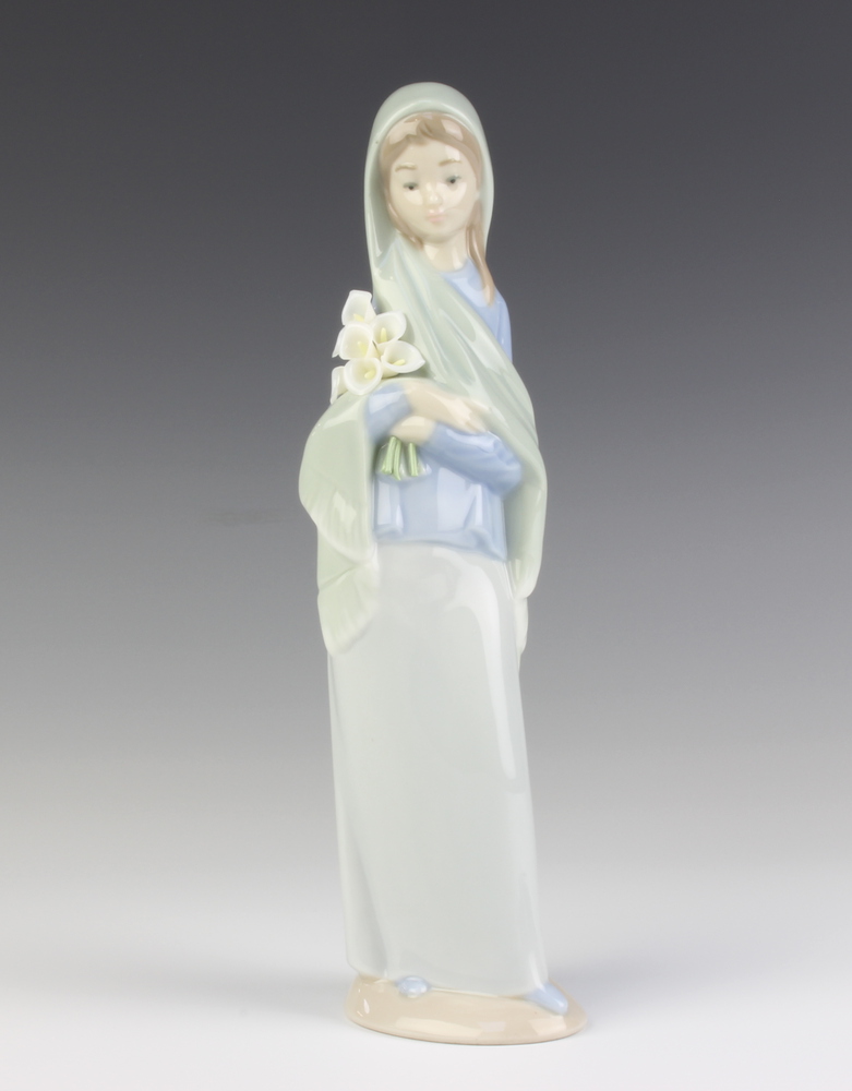 A Lladro figure of a girl holding a bunch of lilies 24cm