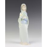 A Lladro figure of a girl holding a bunch of lilies 24cm