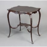 An Edwardian shaped mahogany 2 tier occasional table of serpentine outline with carved apron and