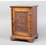 A Victorian carved oak smokers cabinet with fitted interior and secret drawer, enclosed by a