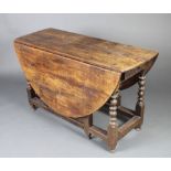 A 17th/18th Century oak oval drop flap gateleg dining table fitted 2 frieze drawers and raised on