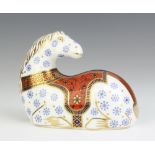 A Royal Crown Derby Imari pattern paperweight of a reclining horse with silver stopper, 9cm