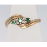 A 9ct yellow gold emerald and diamond crossover ring, size P, 2.8 grams