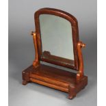 A Victorian arched plate dressing table mirror contained in a mahogany frame, the base fitted a