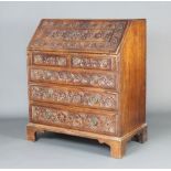A Georgian carved mahogany bureau, the fall front revealing a fitted interior above 2 short and 3