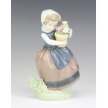 A Lladro figure of a girl holding a pot of flowers 5223 17cm
