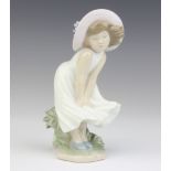 A Lladro figure of a girl with a floral hat