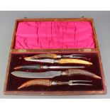 A cased 5 piece horn handled carving set